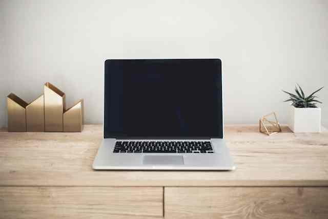 Laptop di meja kerja untuk artikel pembalas email otomatis saat libur atau cuti
